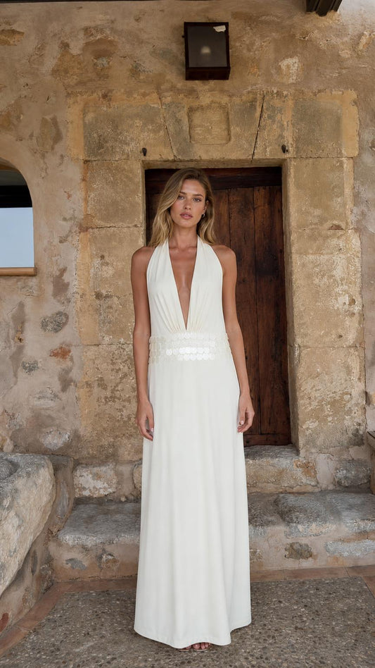 Front view of woman wearing white halter neck maxi dress