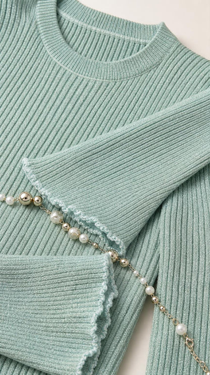 Close-up detail of mint green knit texture and pearl belt